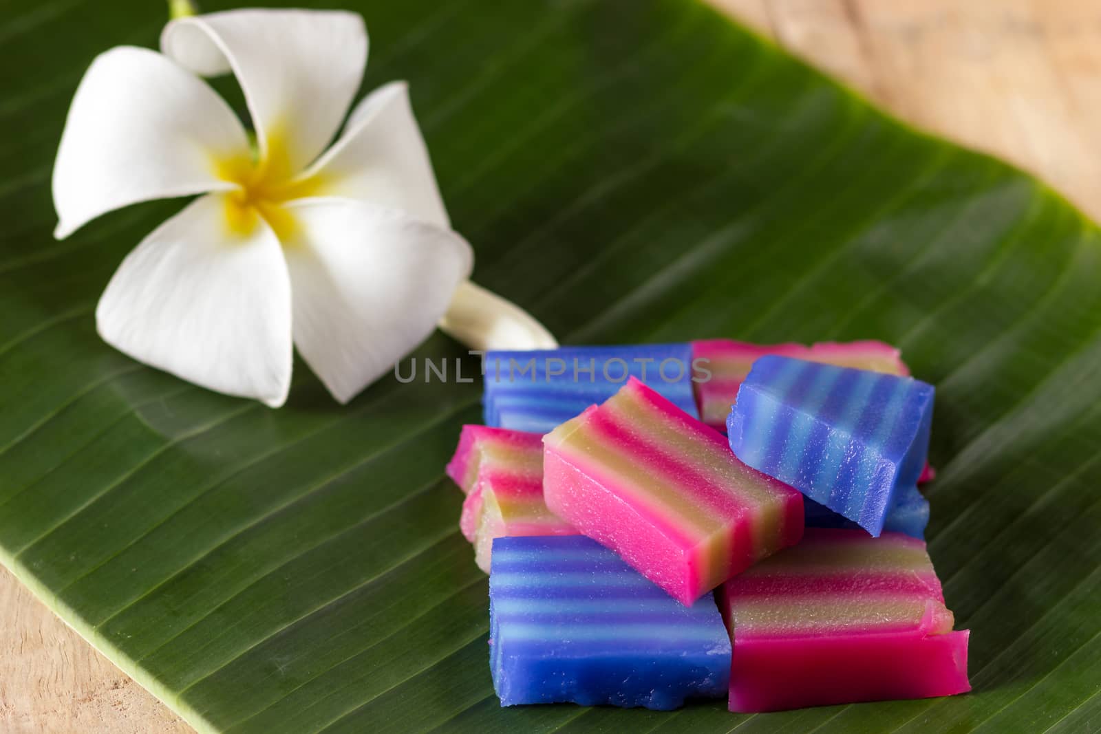 Name is Kanom Chan in Thailand. Put on banana leaf with Plumeria flower.