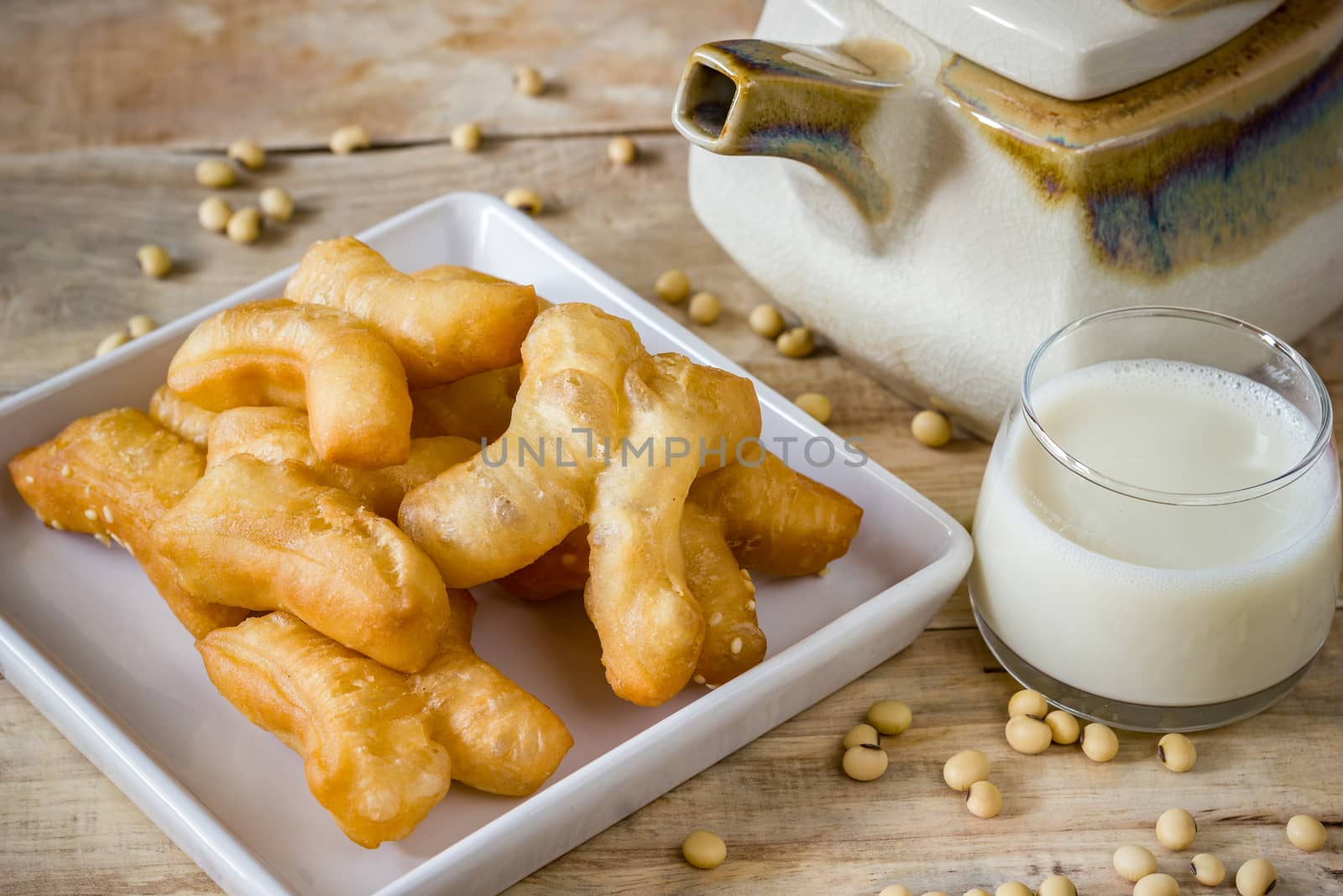 Deep-fried dough stick with Soybean milk and Ceramic hot pot on wood background