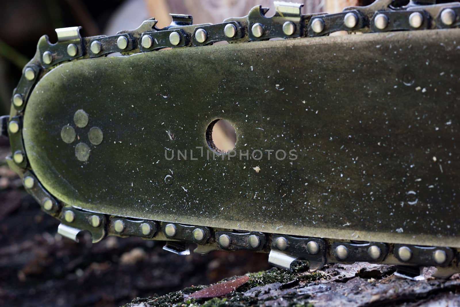 Close up chainsaw and teeth set on a chain around the edge.