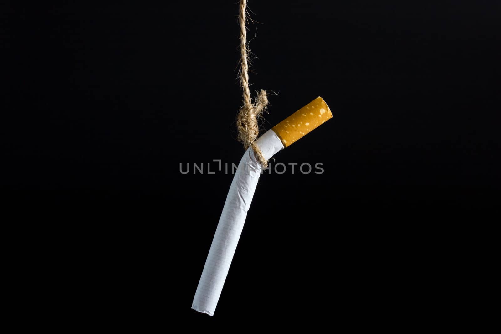 Anti Tobacco, Cigarette was hanged with a rope on dark background.