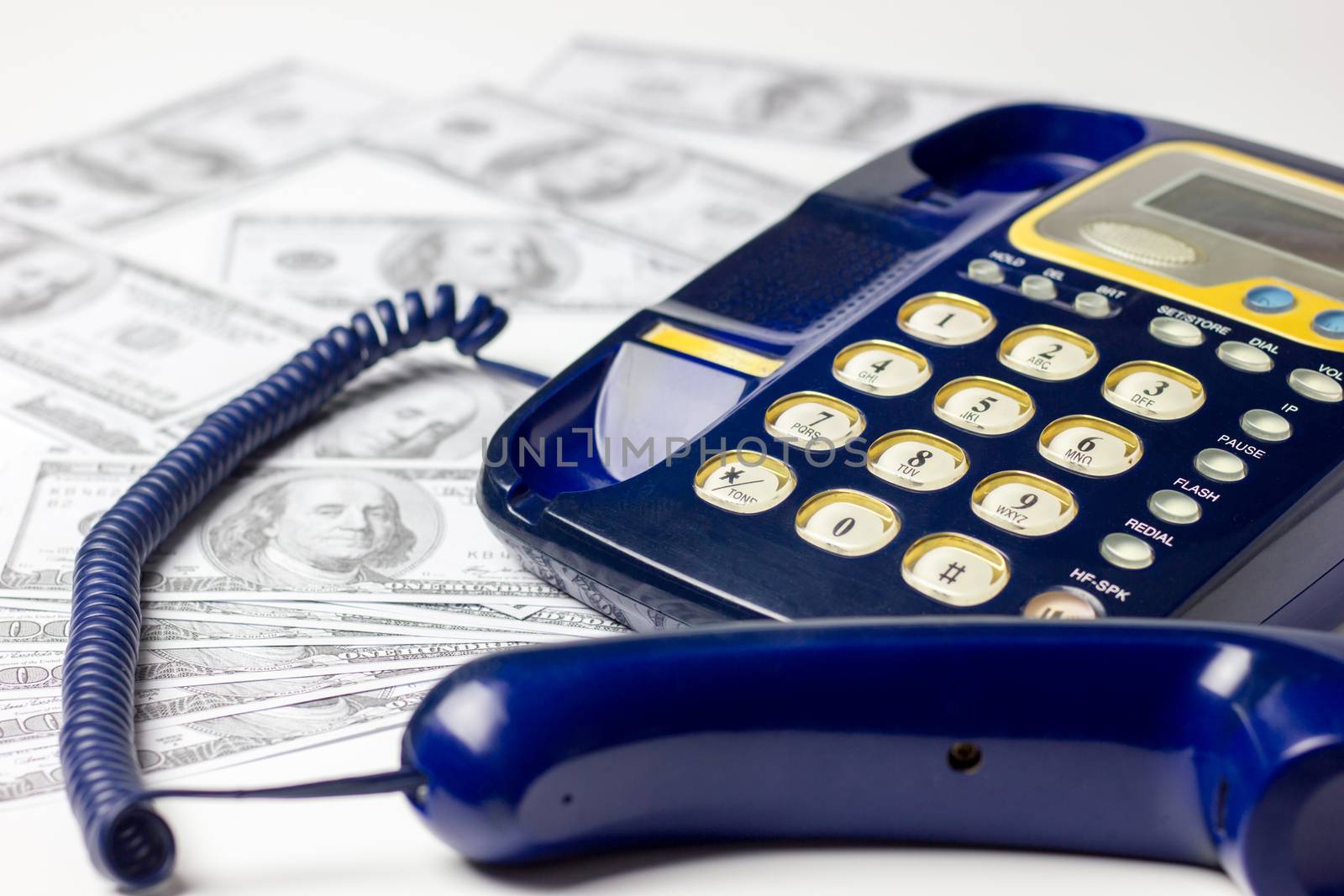 Business and finance. Many dollar is placed beside the landlines on white background.