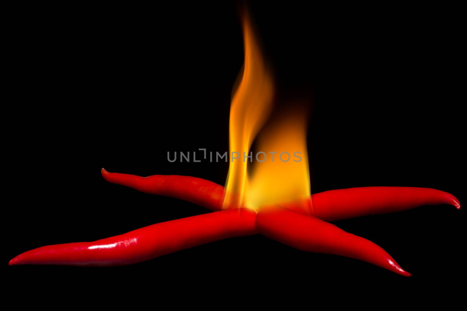 Set fire with chili. Fire on chili pile on dark background.