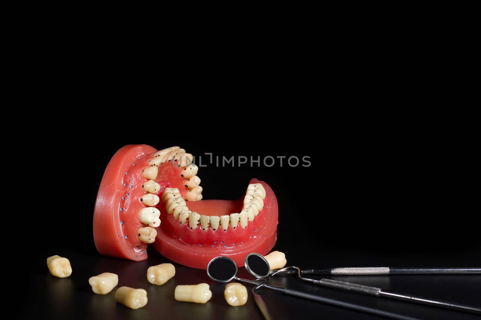 Teeth model and dentist equipment on space black background.