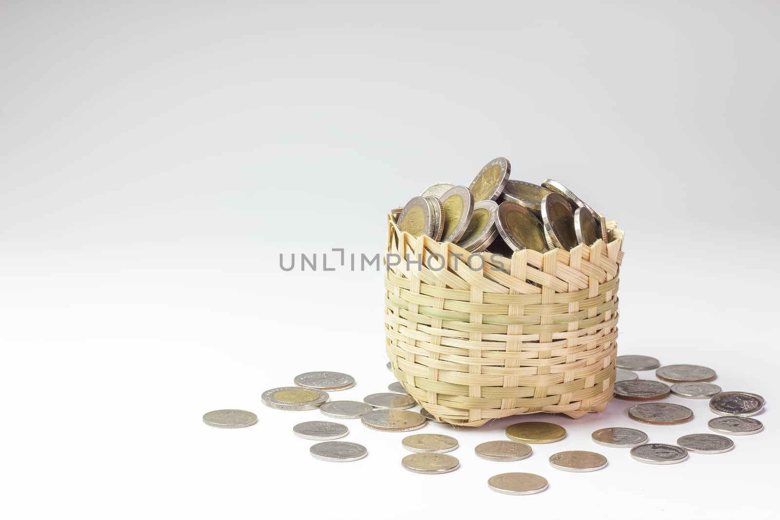 Many coin in a bamboo basket on white background. Concept financial or business. Keep saving money for good thing in the future.