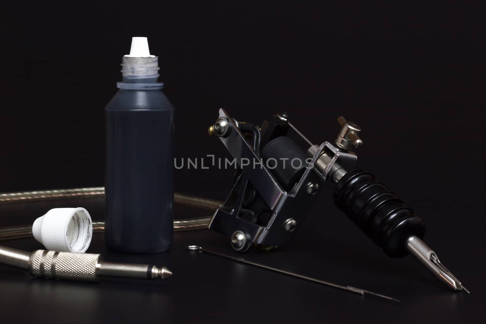 Tattoo machines and Bottles tattoo Ink in darkness. Equipment fo by SaitanSainam