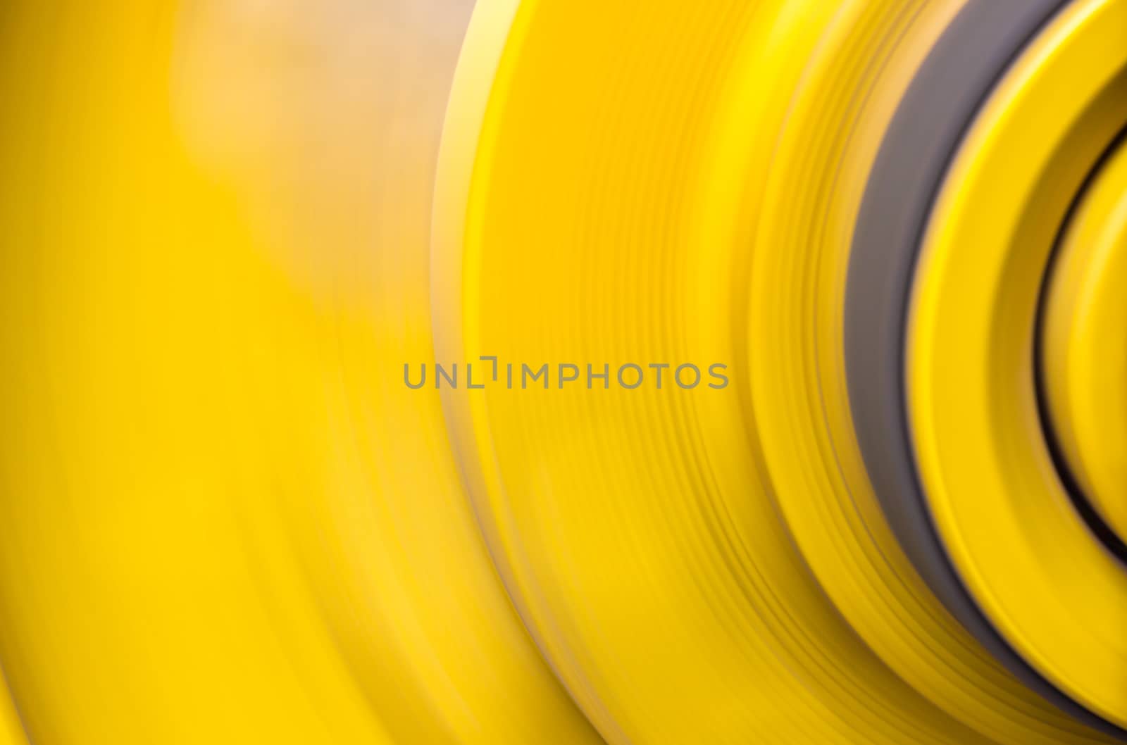 Big yellow pulleys are rapidly rotating by being driven by a conveyor belt.