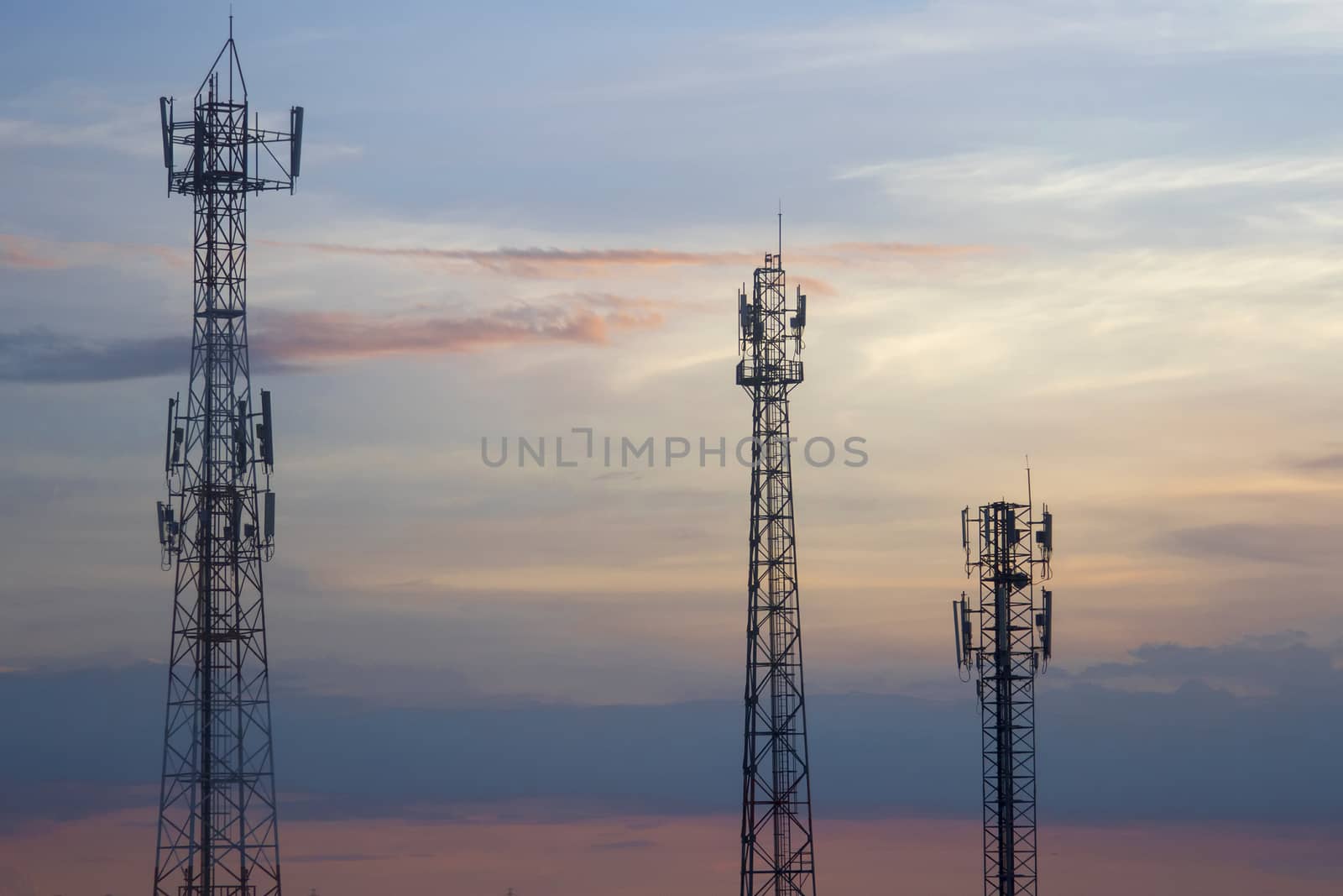 Three mobile phone communication tower transmission  signal  leash in evening sky