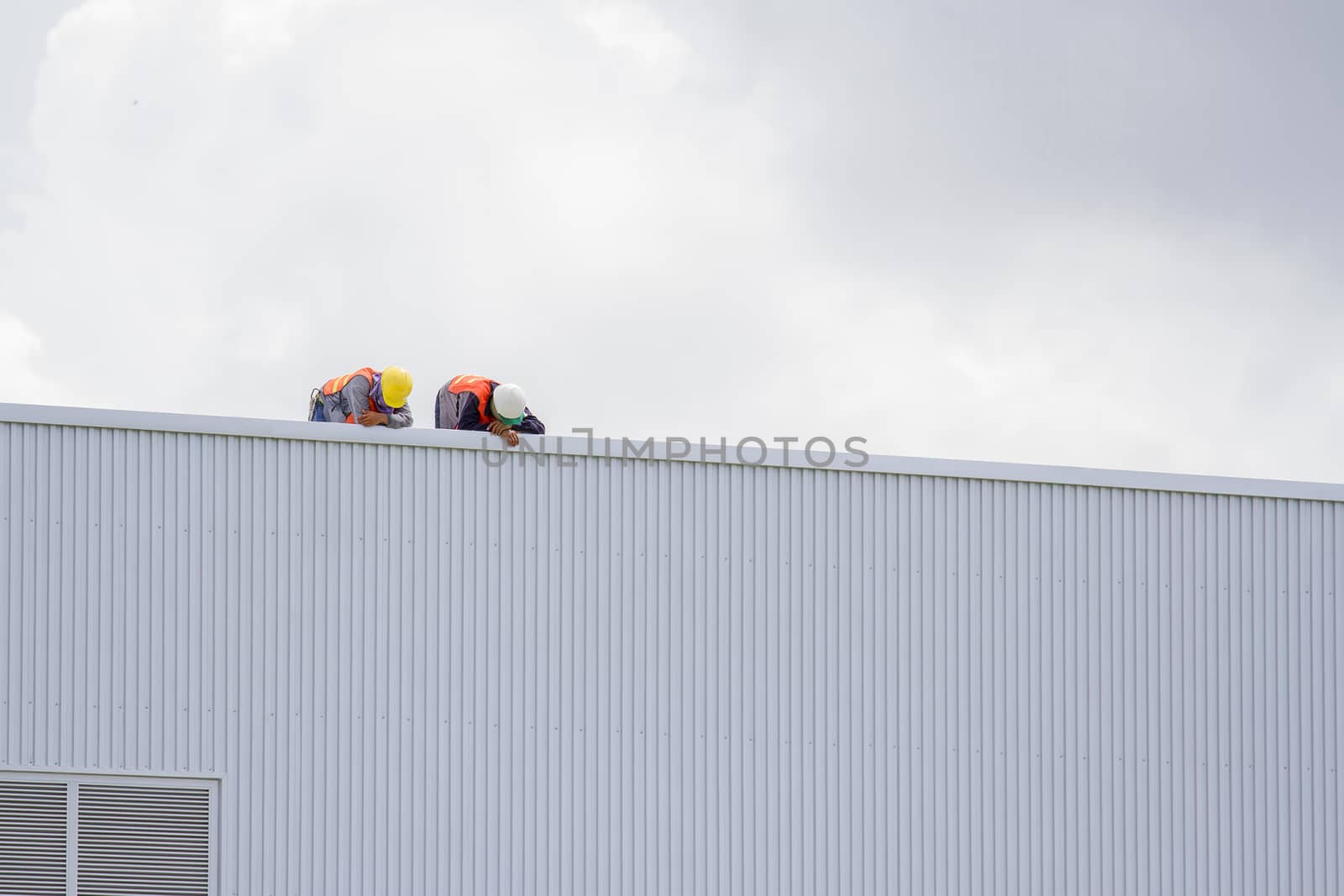 Construction workers on the roof of the building. by TakerWalker