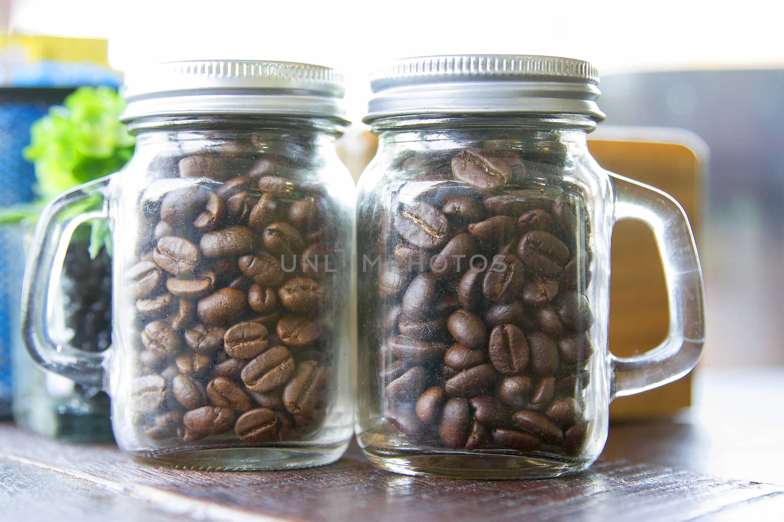 Coffee beans in two bottles placed on the table.