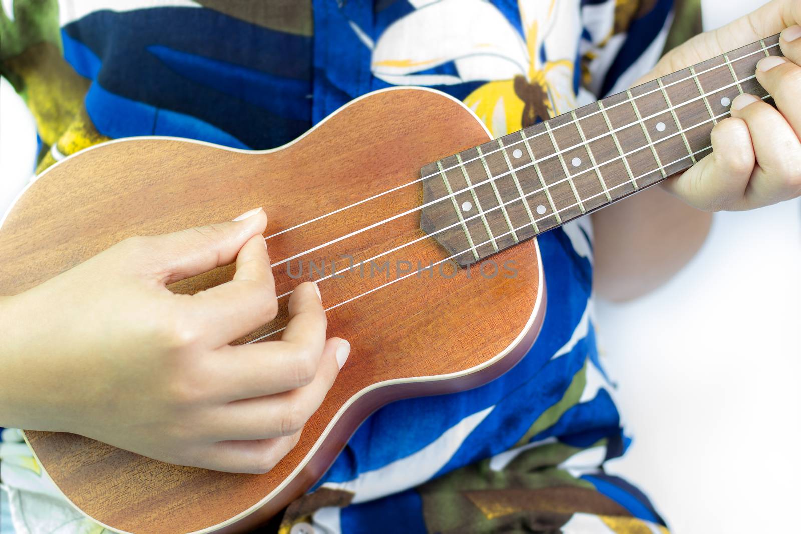 Beautiful girl playing Ukulele on white background. Suitable for music articles or go to Hawaii travel.