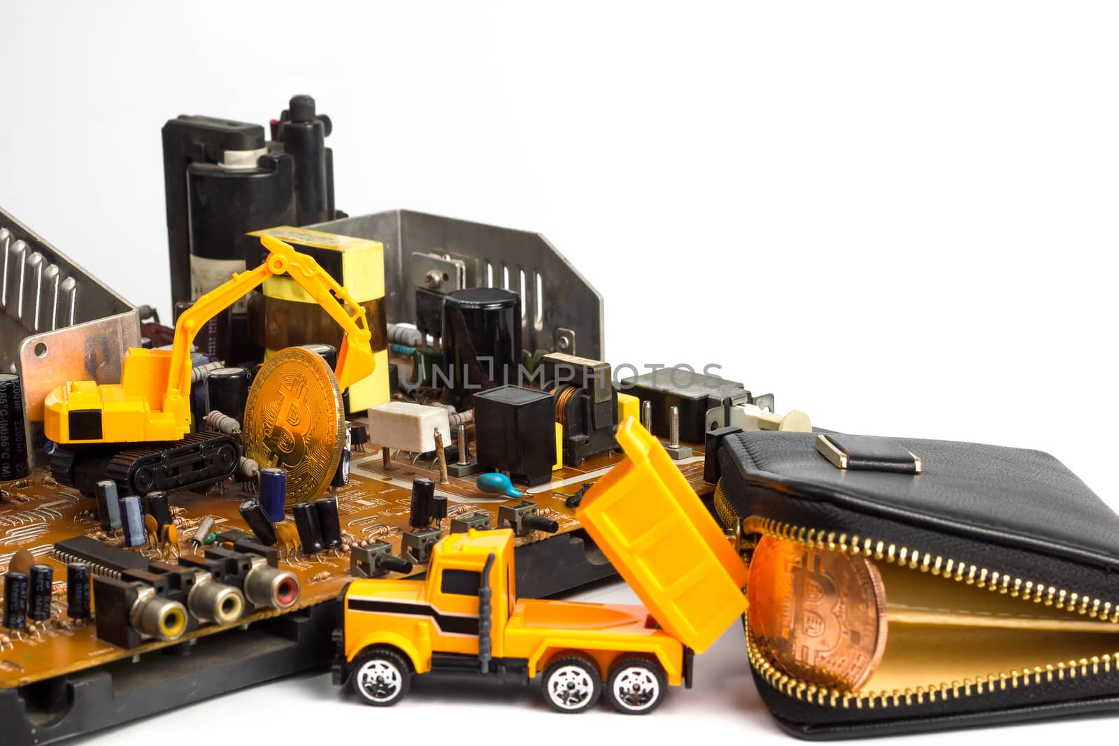 Backhoe dig bitcoin on mainboard put in the truck and transport it to the leather wallet. Concept of bitcoin mining business.