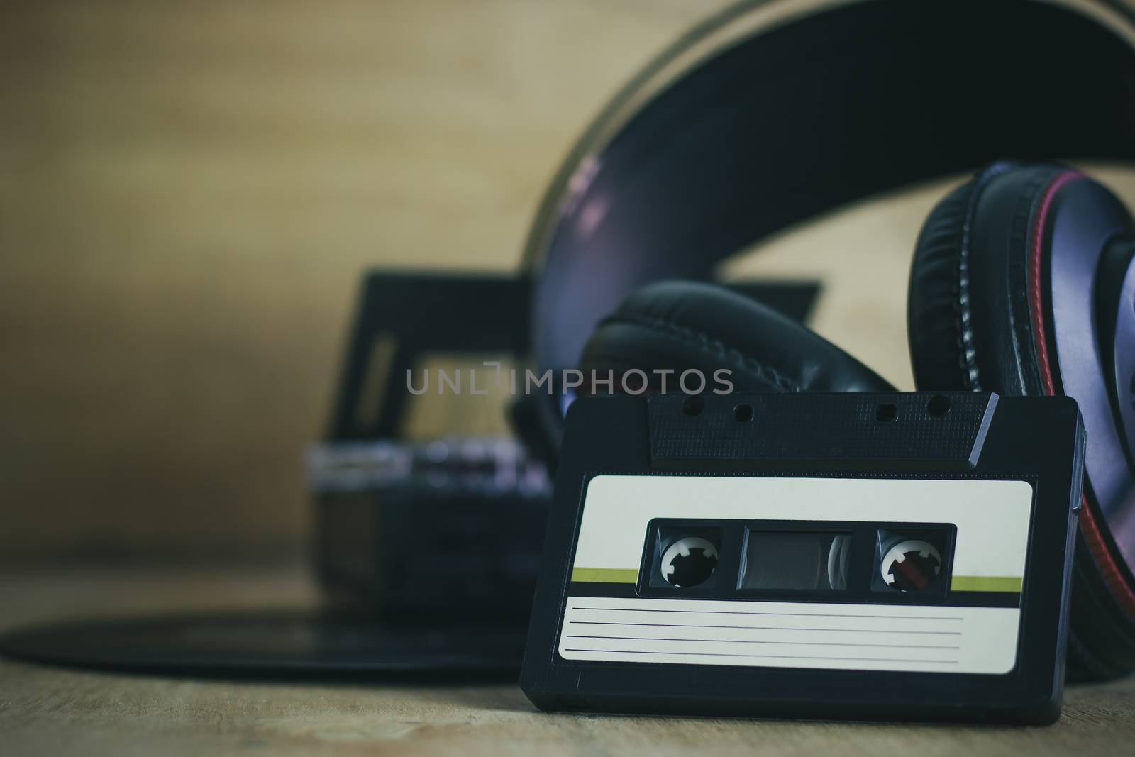 Cassette and headphone with gramophone record platter on wood ba by SaitanSainam