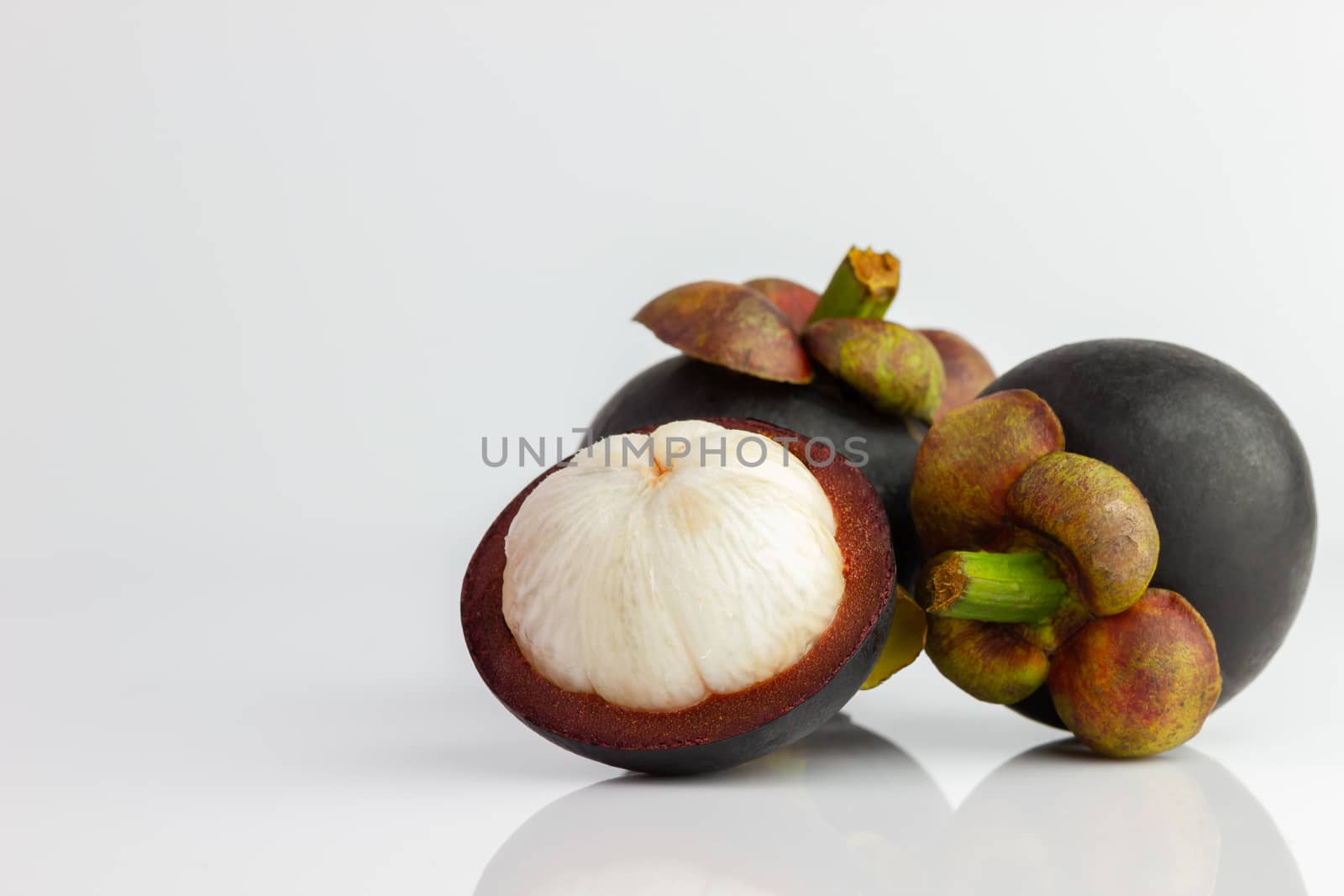 Three of the mangosteen were peeled off on a white background. by SaitanSainam