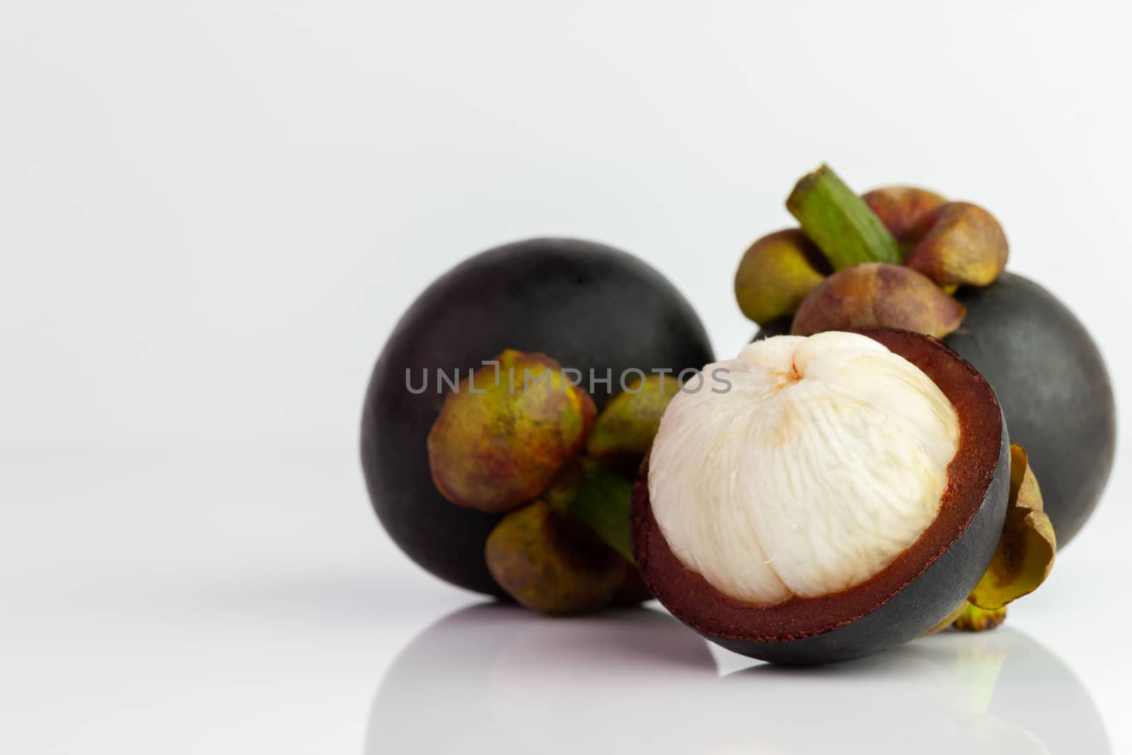 Three of the mangosteen were peeled off on a white background. by SaitanSainam