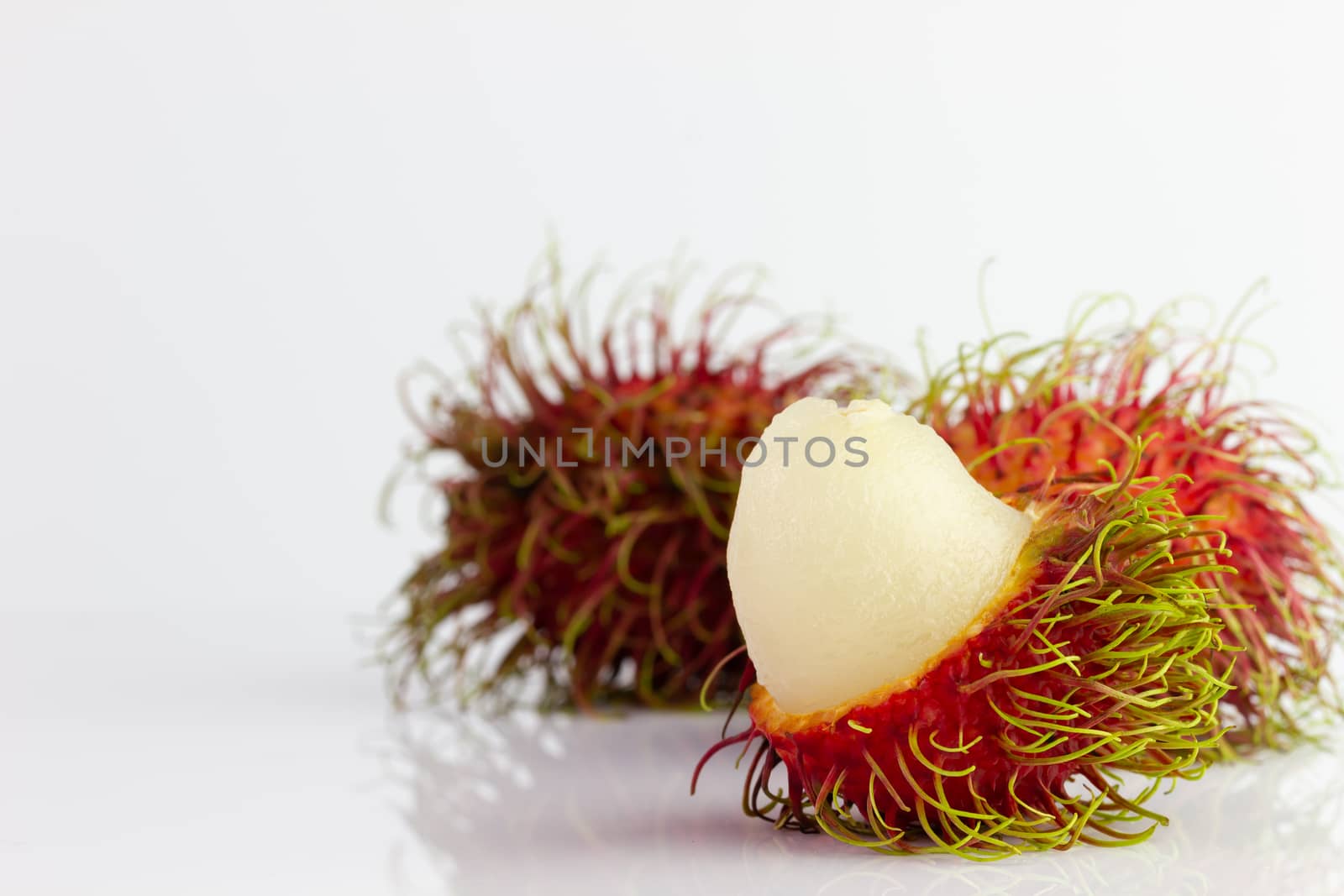 Three rambutans were peeled off on a white background. by SaitanSainam