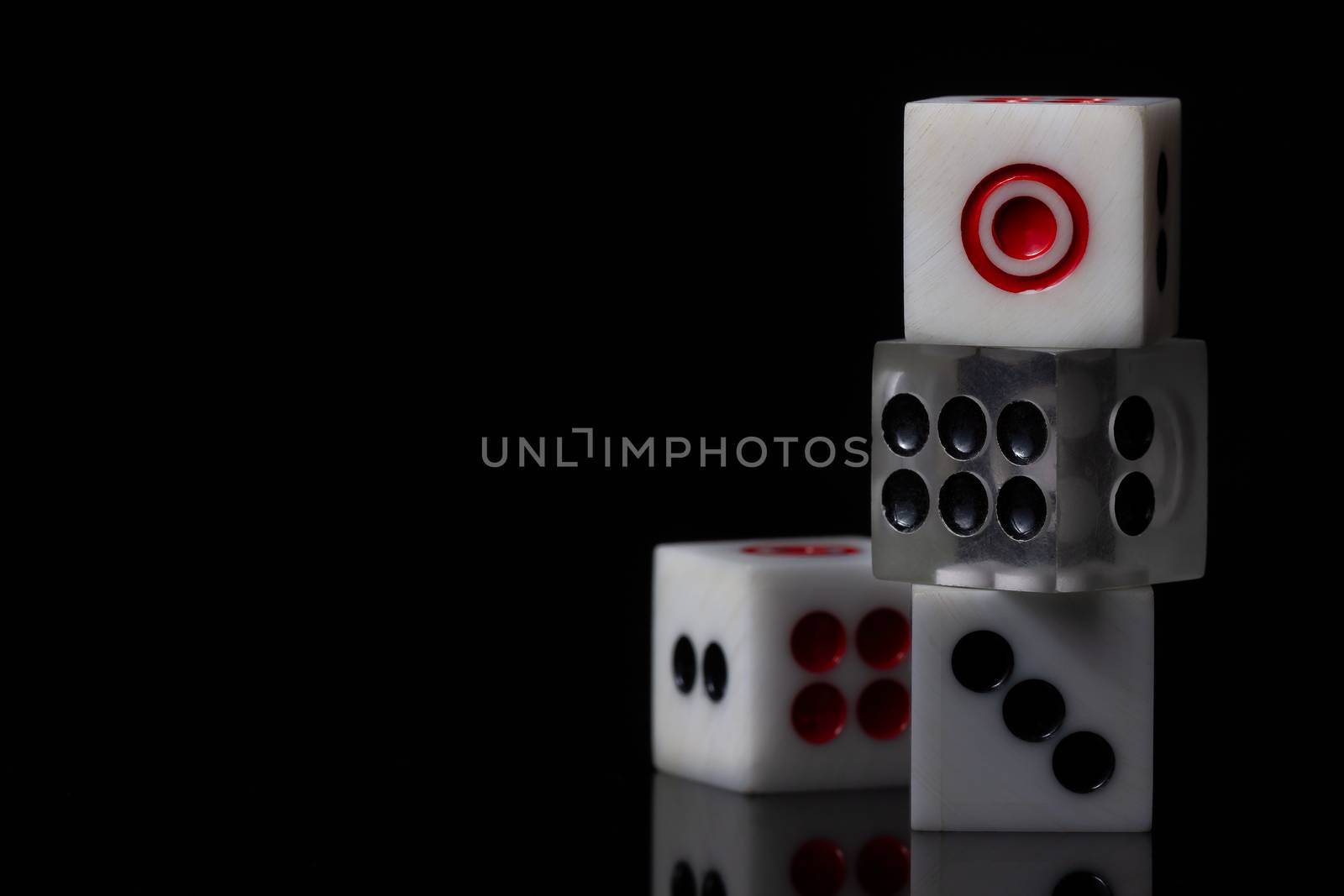 Closeup three dice stacked on dark background. Casino or business concept.