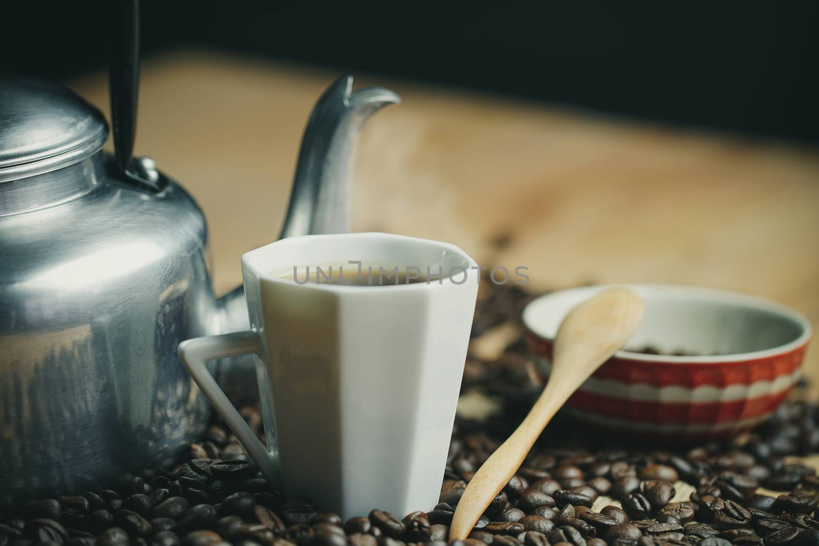 Coffee cup and hot pot. Roasted coffee beans on brown wood backg by SaitanSainam