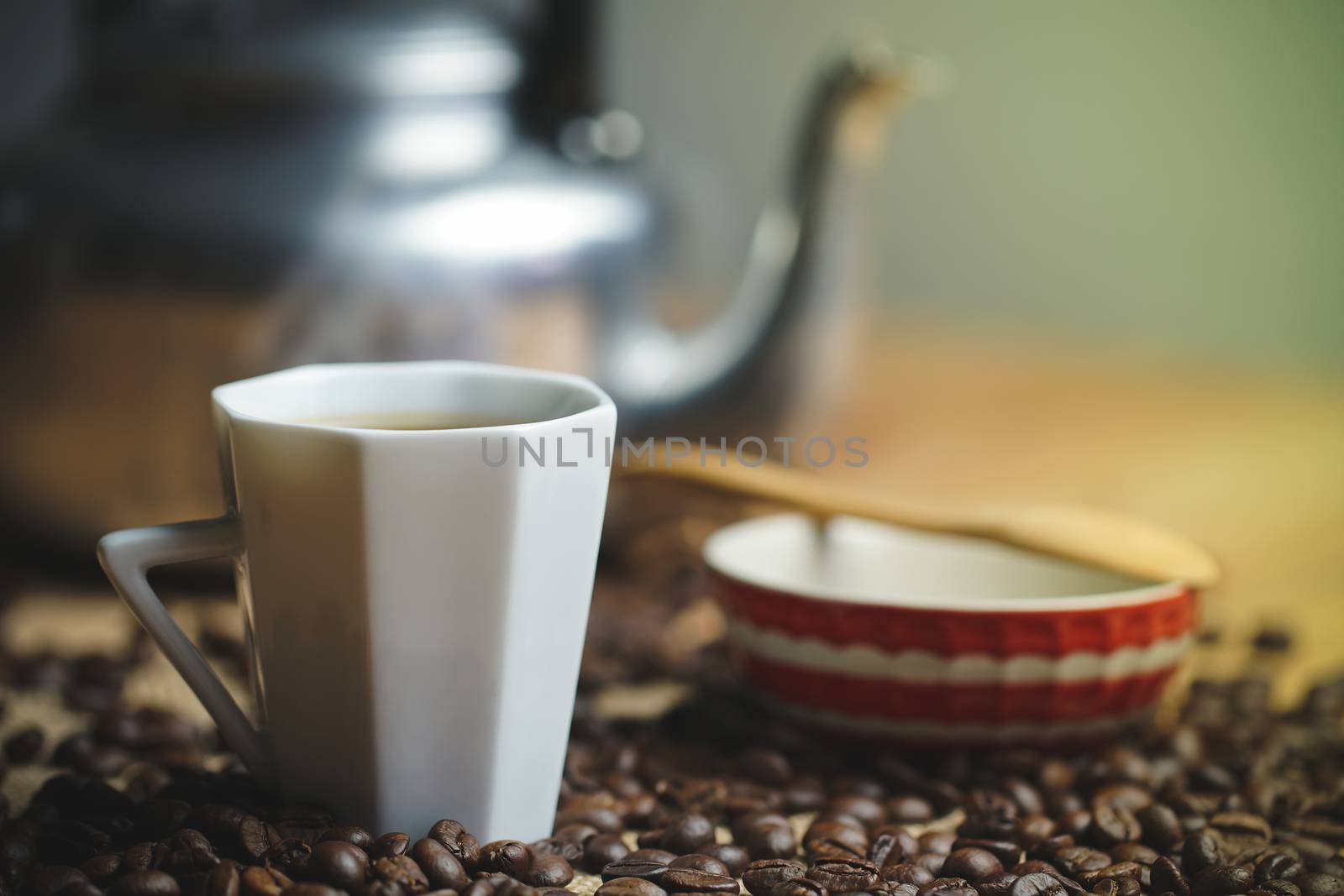 Coffee cup and hot pot. Roasted coffee beans on brown wood background in morning.