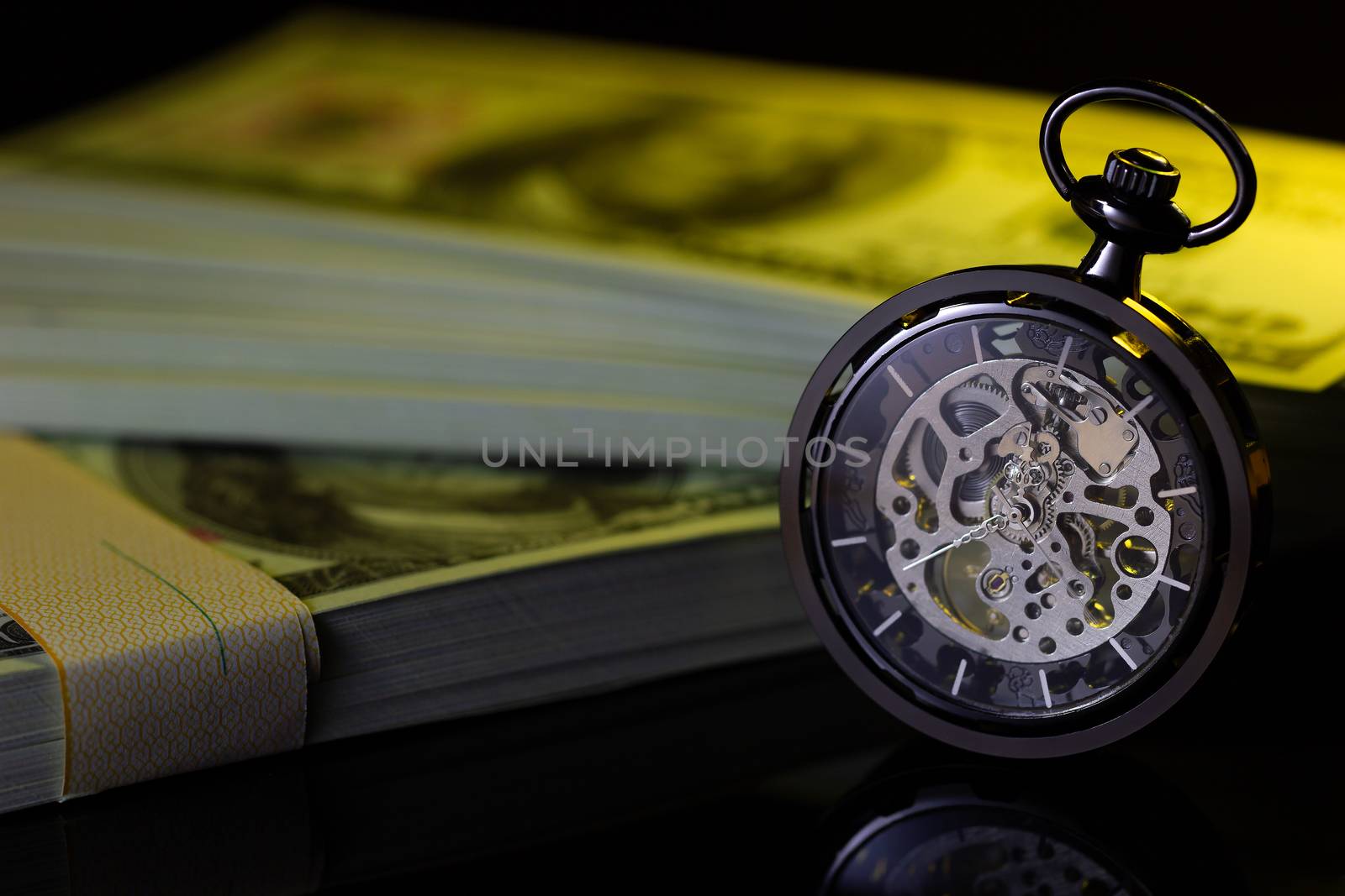 Vintage pocket watch and fake dollar banknote in darkness. Concept of Time is money business.