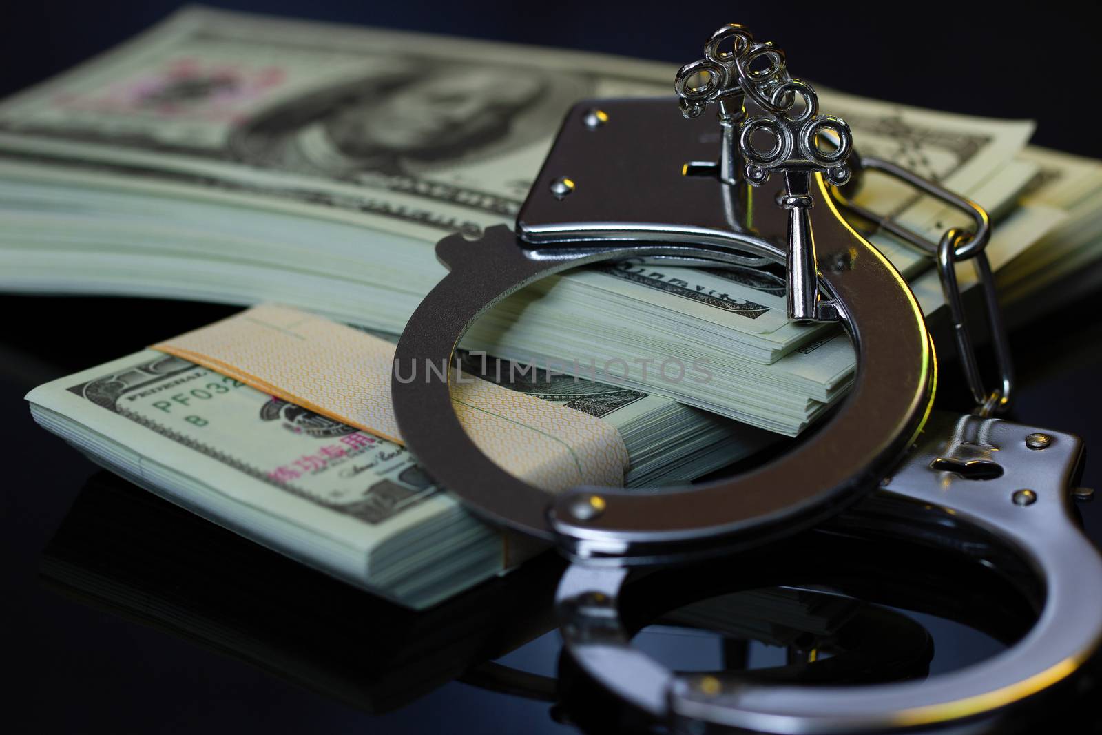 Handcuffs and money in the darkness. Concept of Business fraud and Corruption.