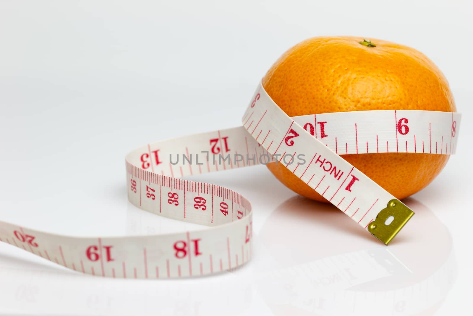 Closeup tangerine was wrapped around it with measuring tape. The concept of love and health care or diet.