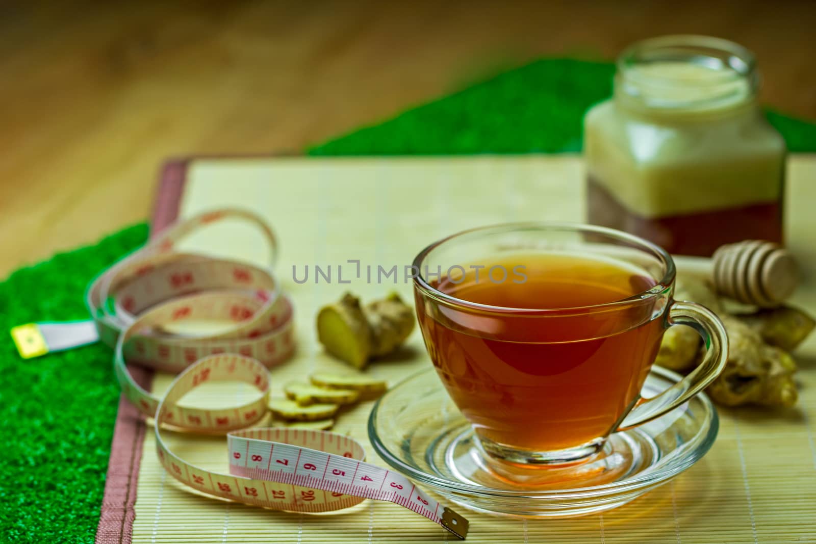 Ginger juice in a clear cup and honey jar placed beside with mea by SaitanSainam