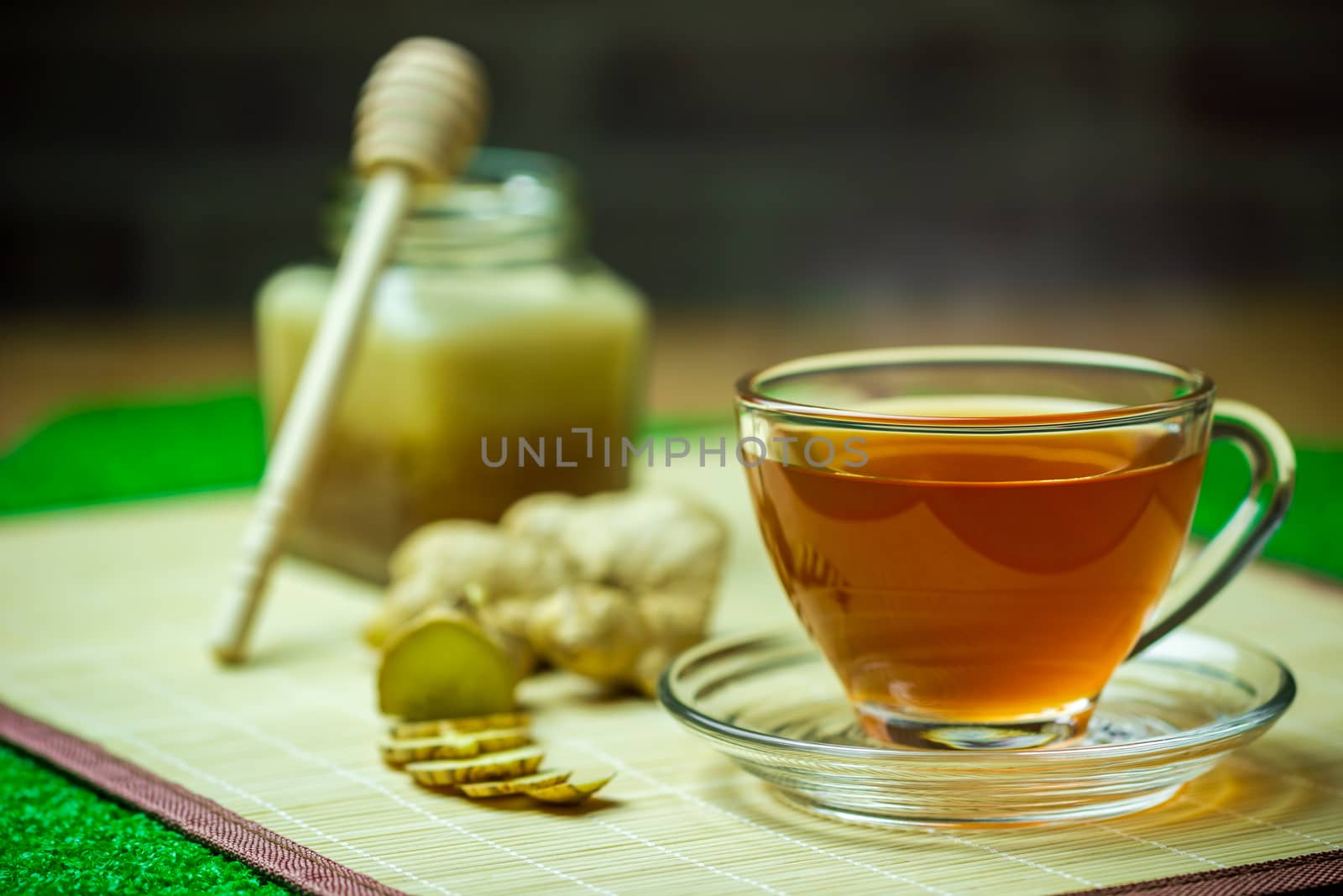 Ginger juice in a clear cup and honey jar placed beside with mea by SaitanSainam