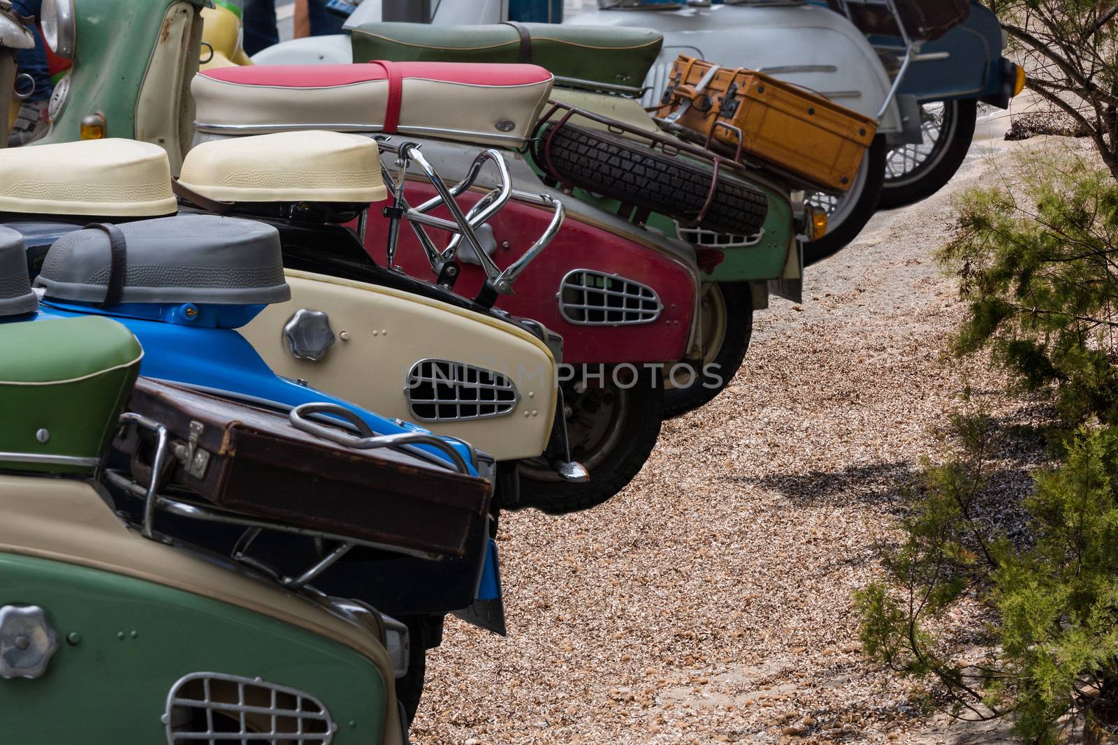 Various retro scooters line the road in a row.