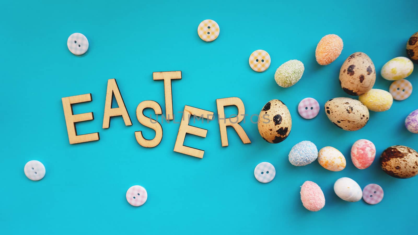 Quail Easter eggs on blue background. Flat lay, top view. Easter concept banner. Easter text