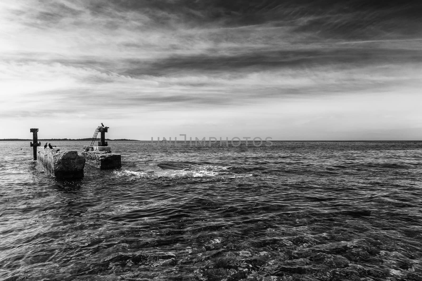 abandoned old pier against black cloudy sky