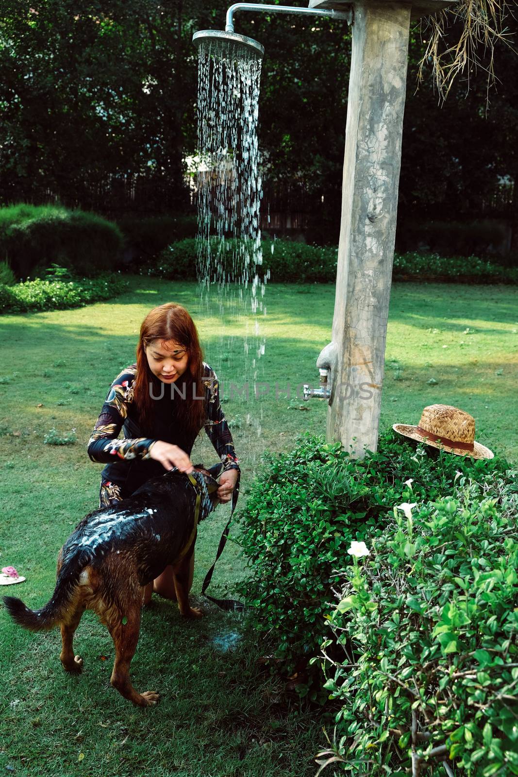 Asian woman washing her pet dog