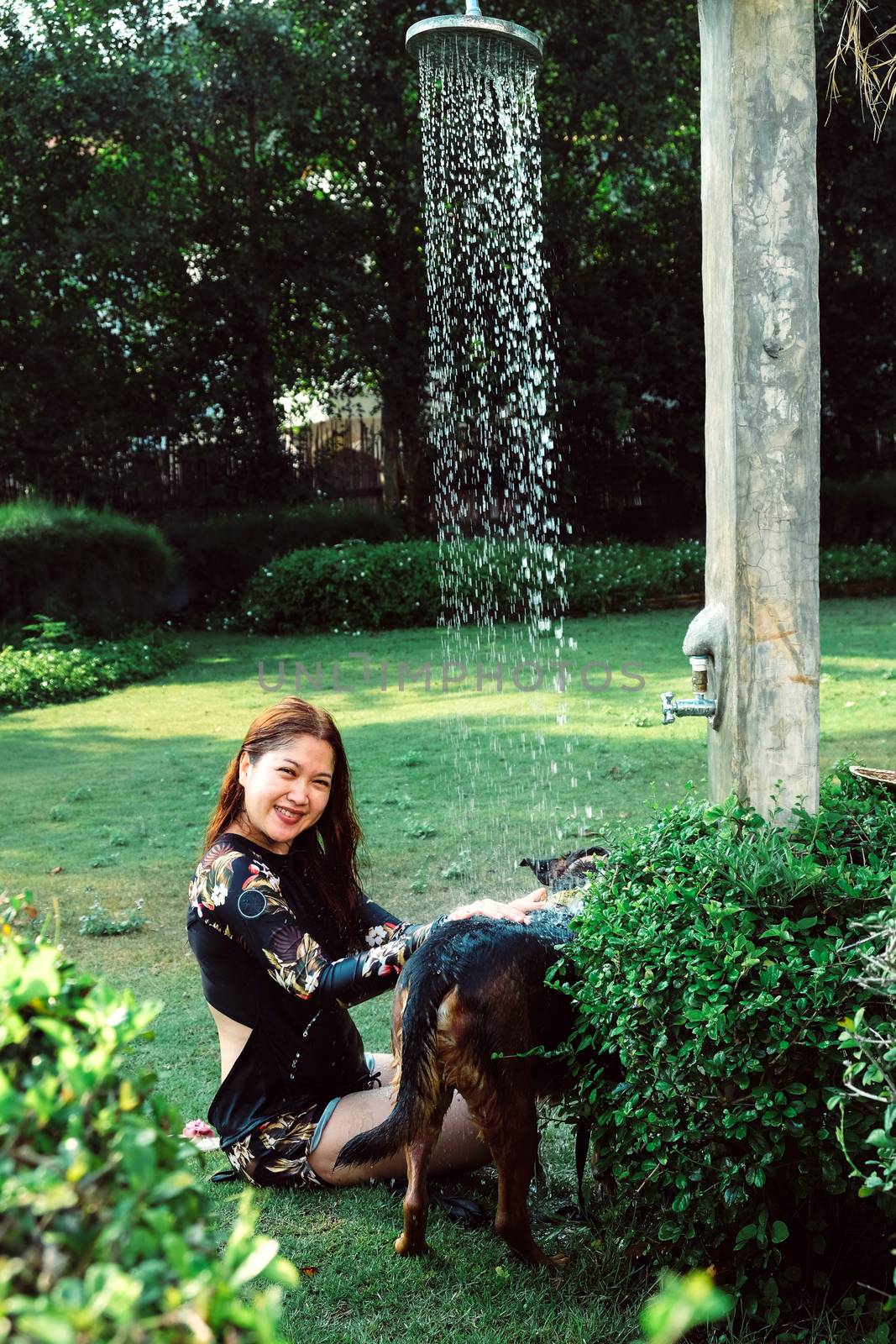 Asian woman washing her pet dog by ponsulak