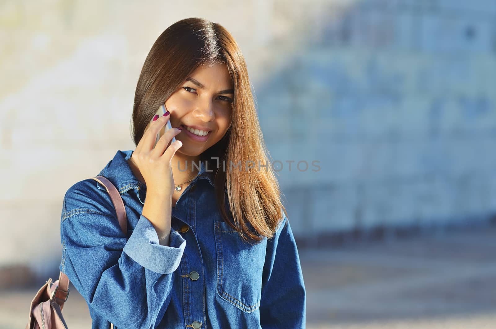 Portrait of a girl who talks on the phone and walks around the city