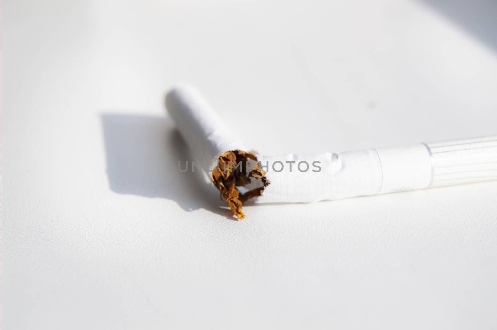 Broken cigarette on white background, Smoking cessation concept, minimalism style, selective focus.