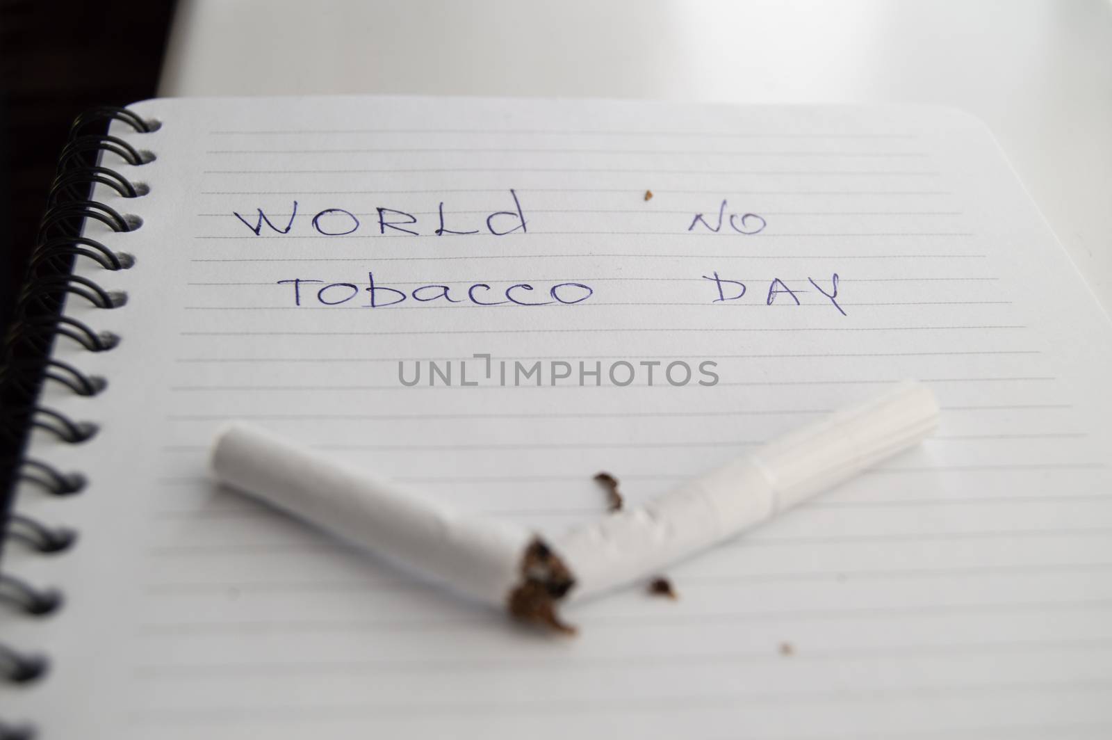 World no tobacco day, no Smoking day. Broken cigarette on business notebook, minimalism.