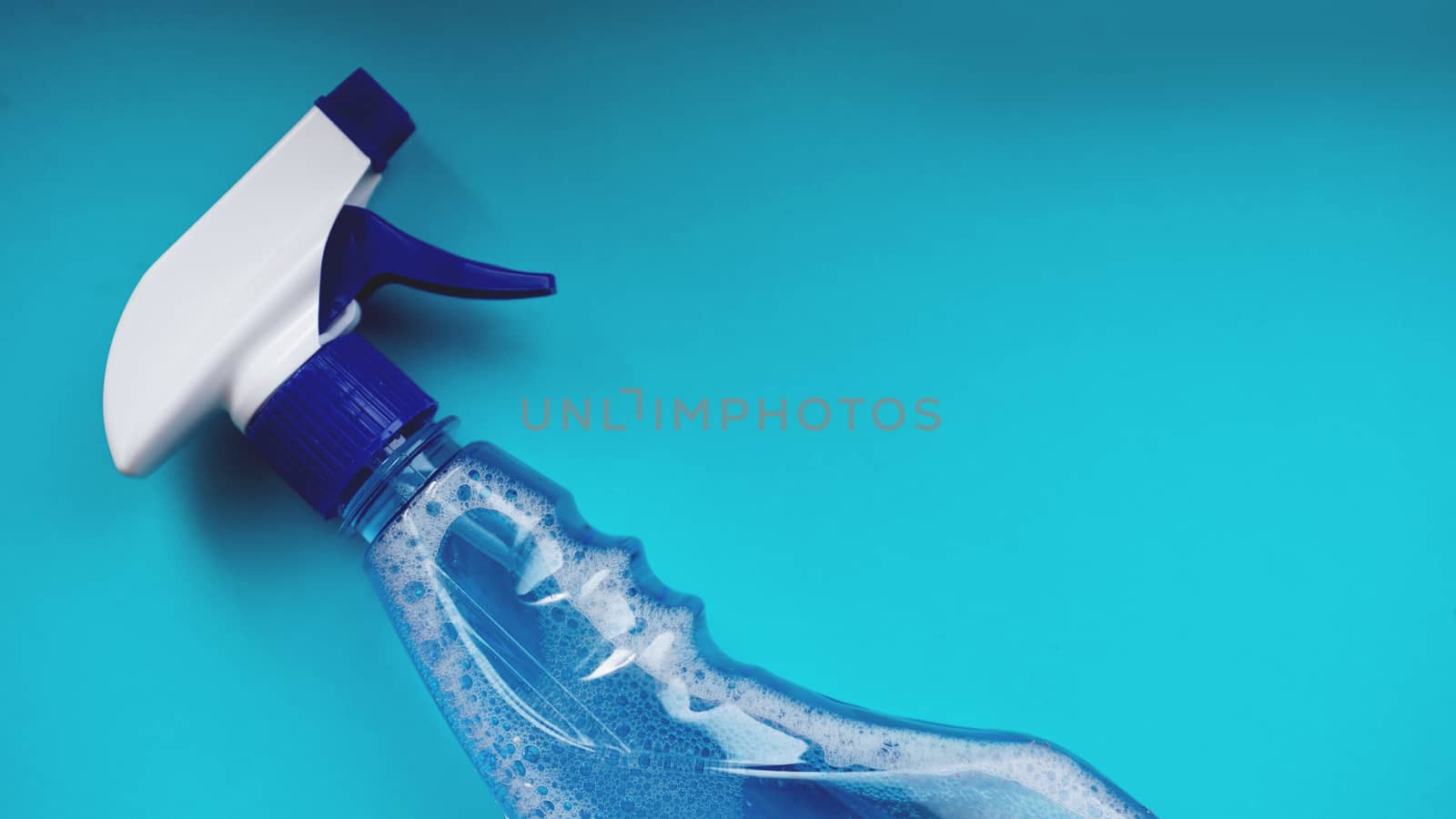 Spray with detergent on blue background. Housework, housekeeping and household concept
