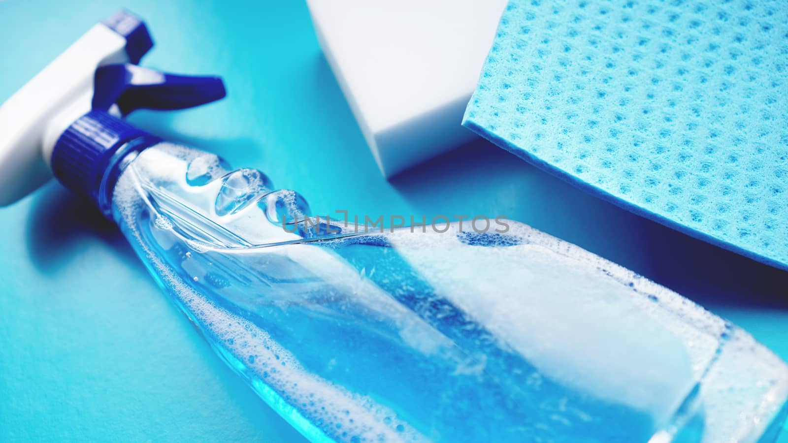 Housework, housekeeping and household concept - cleaning rag, detergent spray on blue background