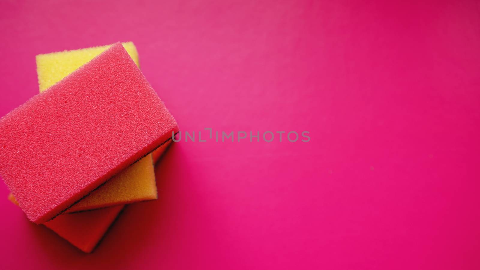 Household cleaning concept. Colorful sponges on pink background by natali_brill