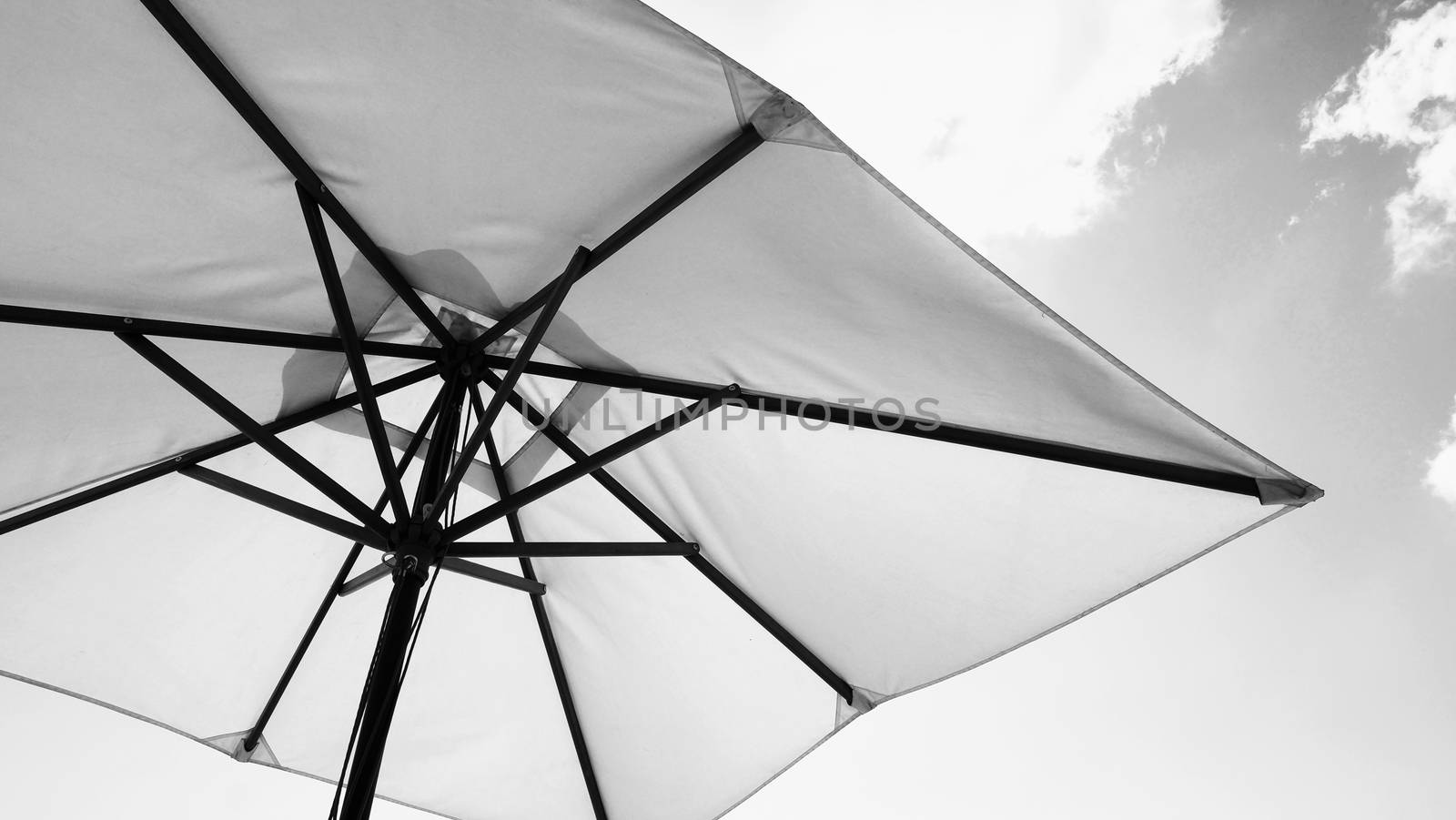 White fabric color texture beach umbrella and brown wood tripod with white cloud and clear blue sky summer sunlight day in low angle view camera for travel asia Thailand Pattaya.