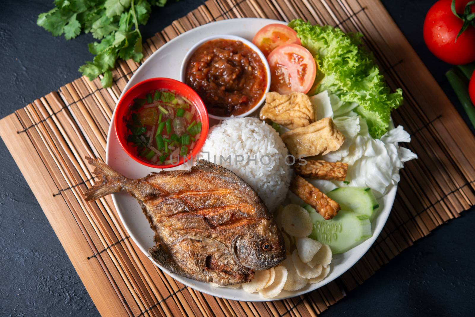 Fried pomfret fish and rice, popular traditional Malay or Indonesian local food. Flat lay top down overhead view.