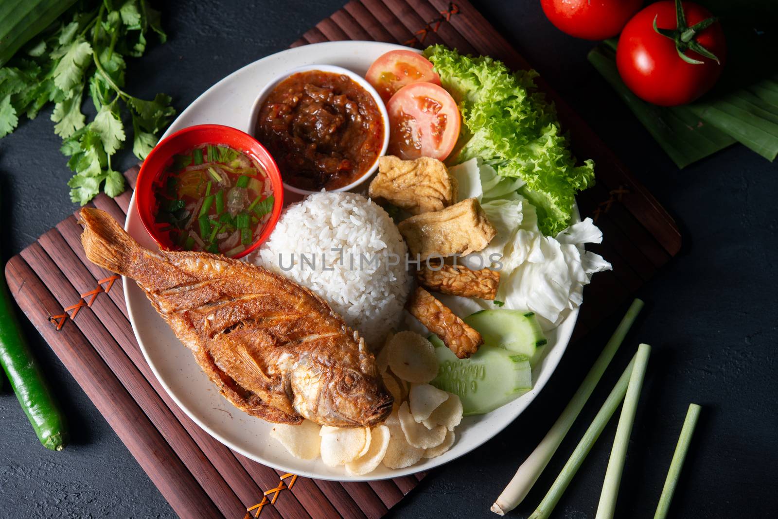 Fried tilapia fish and rice, popular traditional Malay or Indonesian local food. Flat lay top down overhead view.