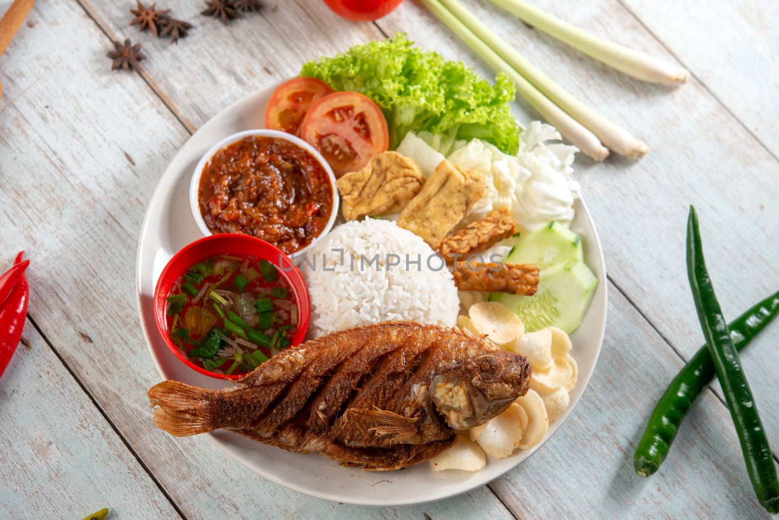 Fried tilapia fish and rice, popular traditional Malay or Indonesian local food. Flat lay top down overhead view.