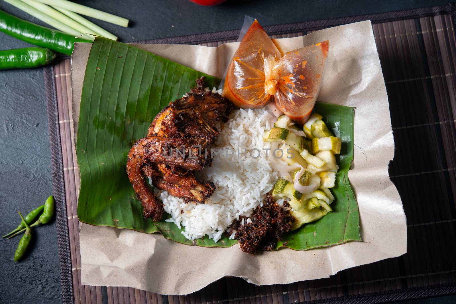Nasi lemak kukus with quail, popular traditional Malay local food. Flat lay top down overhead view.