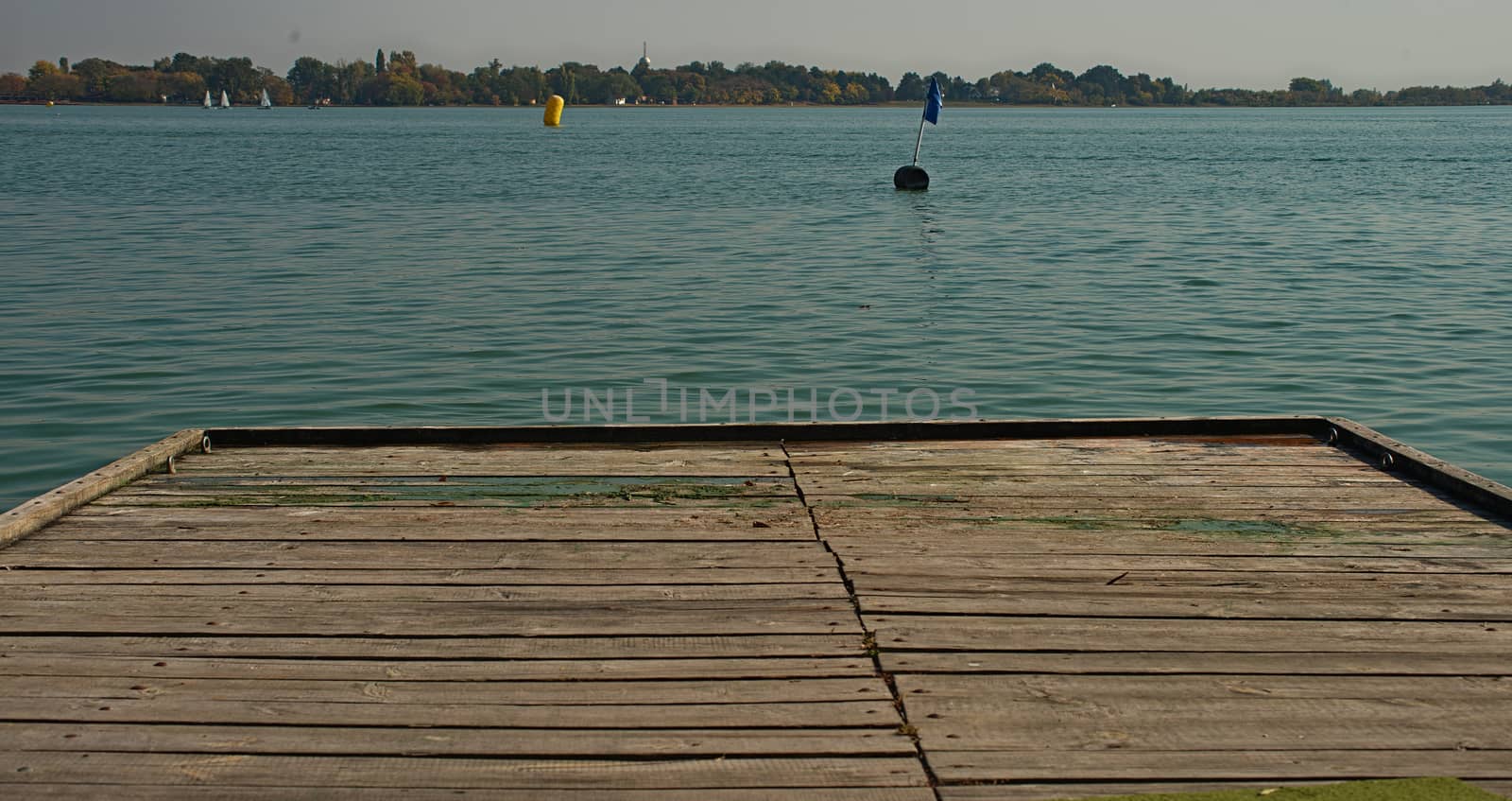 Rustic wooden pier and lake with other shore by sheriffkule