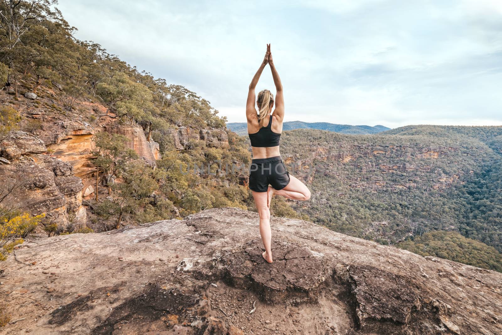 Female strength yoga balance asana mountain cliff ledge by lovleah