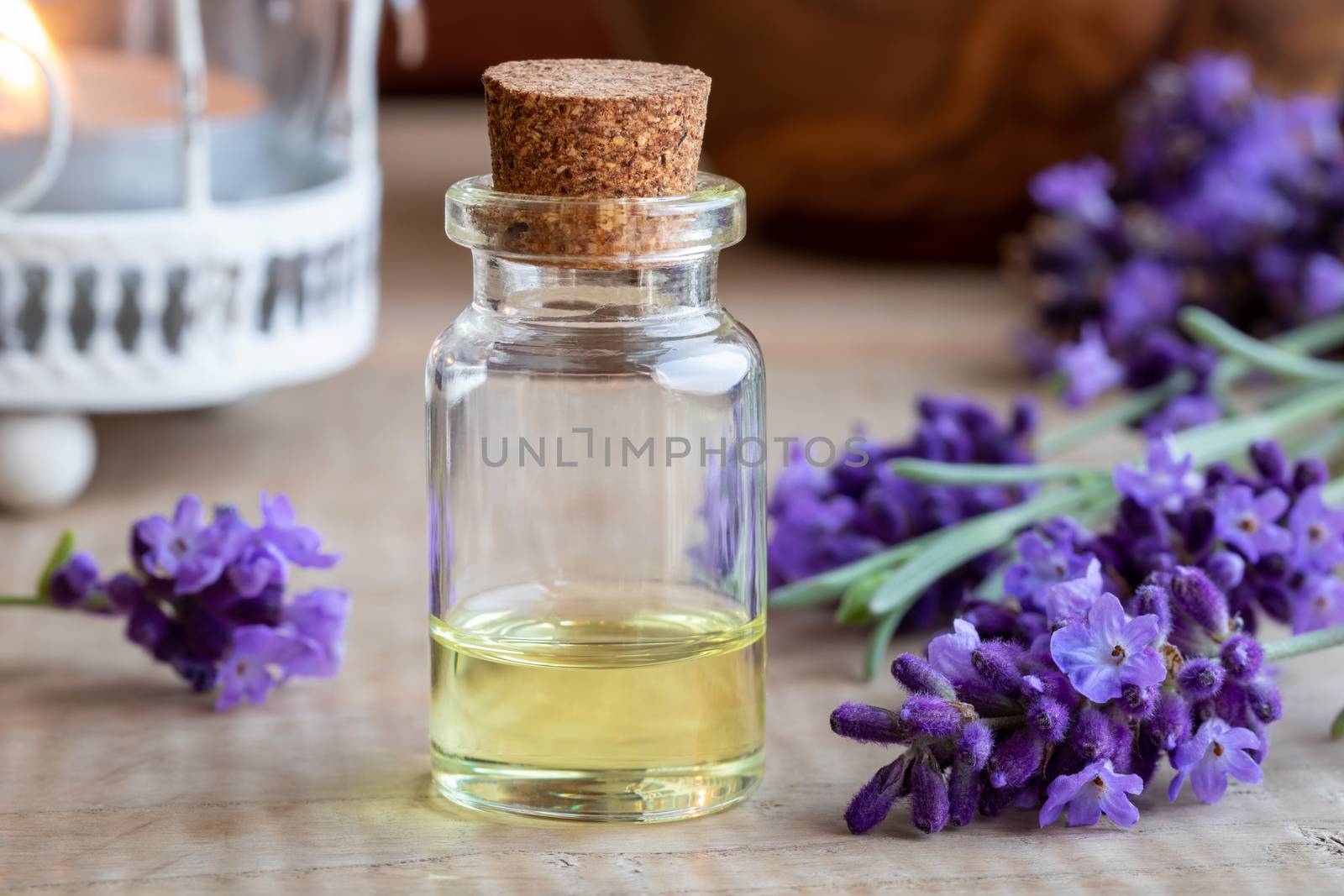 A bottle of lavender essential oil with fresh blooming lavender by madeleine_steinbach