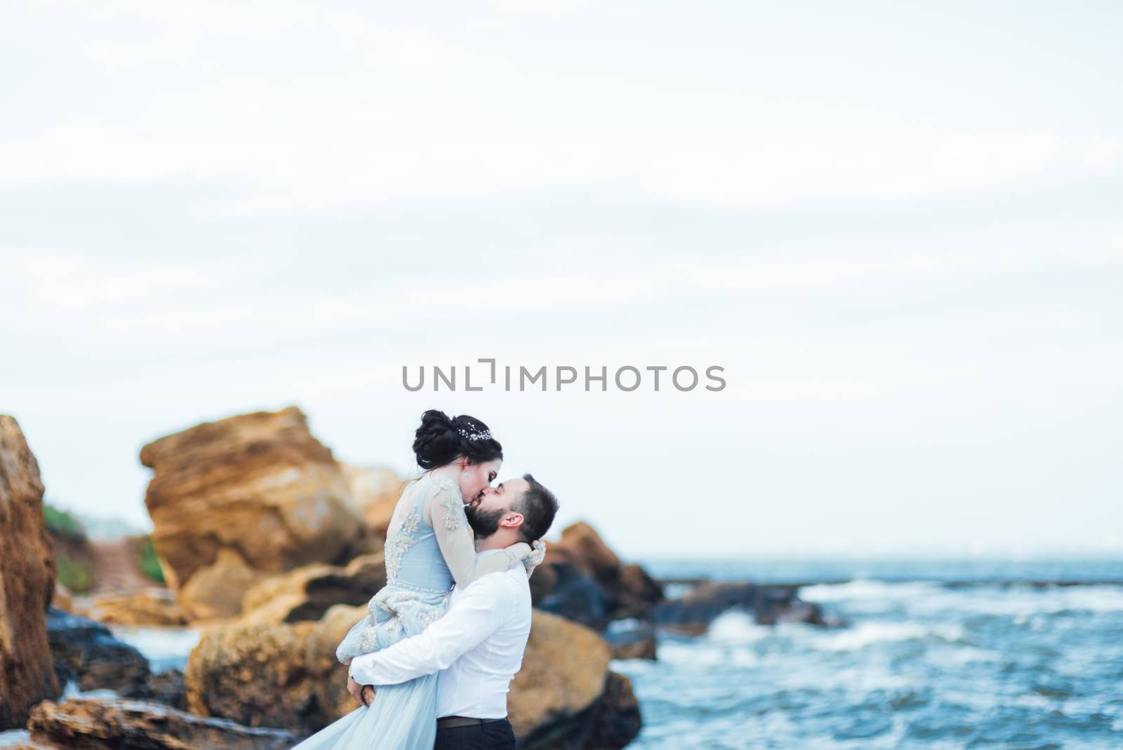 same couple with a bride in a blue dress walk by Andreua