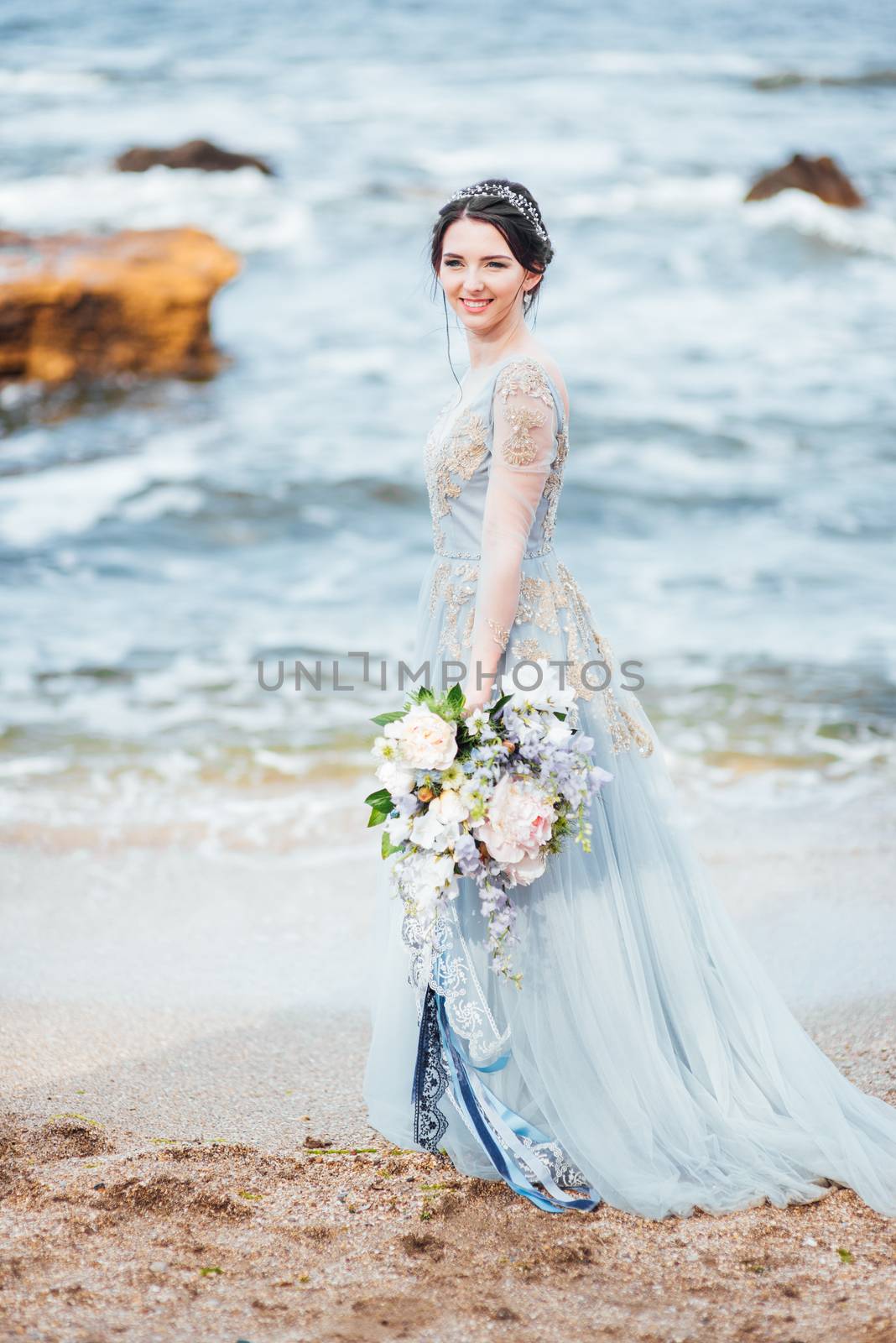 bride with a bouquet of flowers on the beach by Andreua