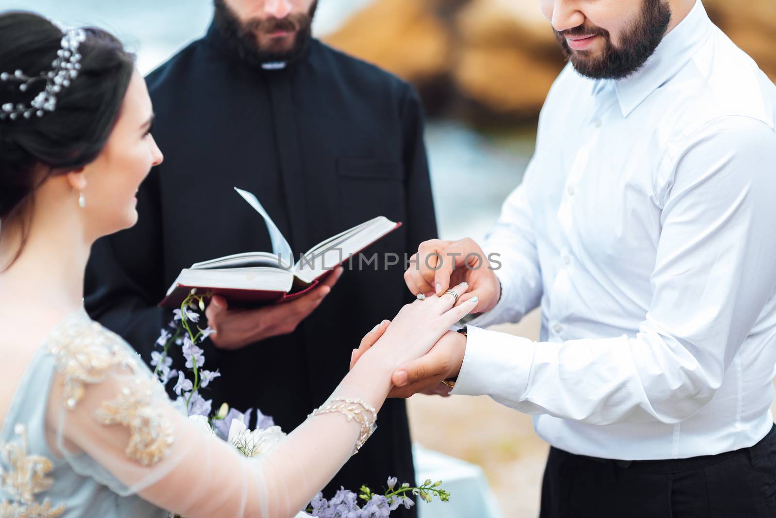 wedding couple on the ocean with a priest by Andreua