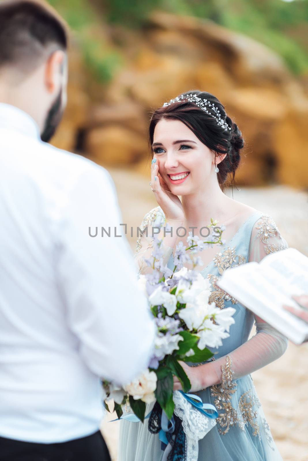 wedding couple on the ocean with a priest